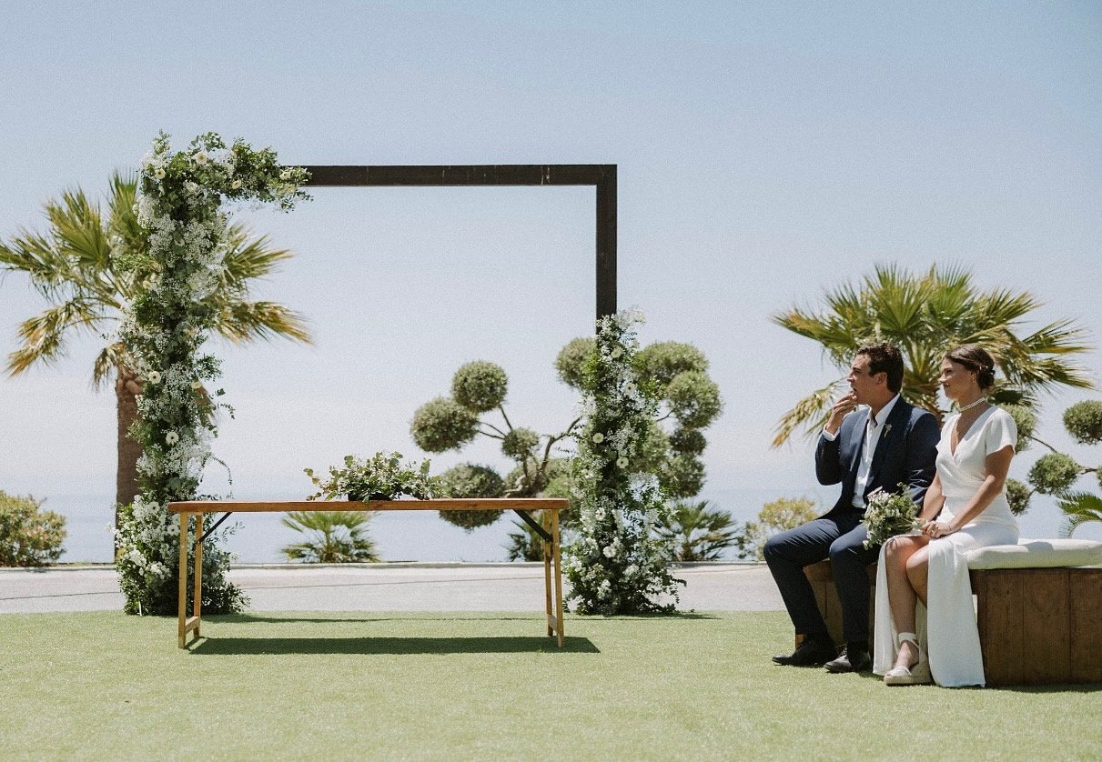 Ceremonia de boda con arco floral frente al mar