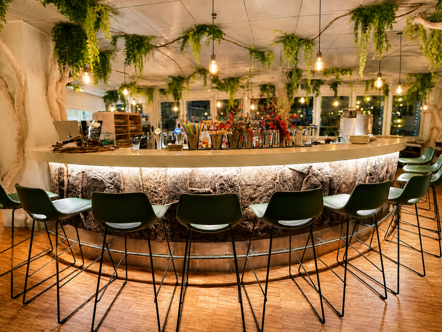 Bar con decoración vegetal suspendida y luz cálida